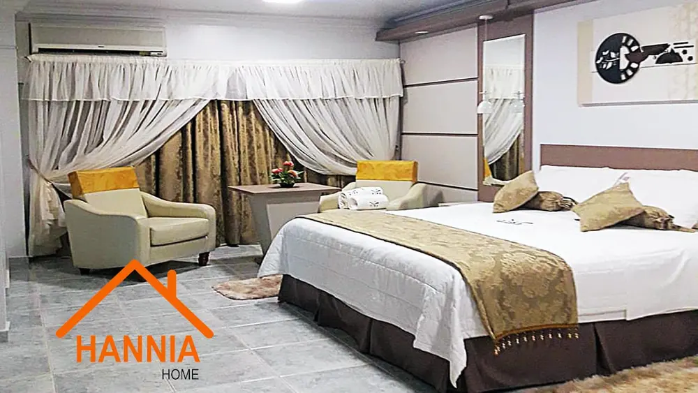 Dormitorio con cama, cortinas y sillón