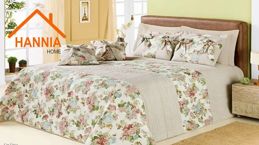 Cama con colcha floreada y almohadones