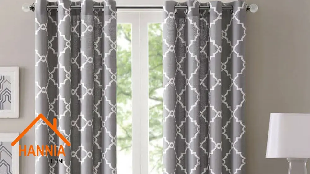 Cortinas de tela gris con diseño geométrico frente a una ventana